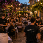soirée clôture de fin de saison à la bonne nuit, terrasse avec des clients et des serveurs et serveuse, et groupe de musique en fond