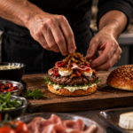 préparation du burger la bonne nuit avec du jambon cru, du fromae de chevre, du steak de boeuf et des oignons confits