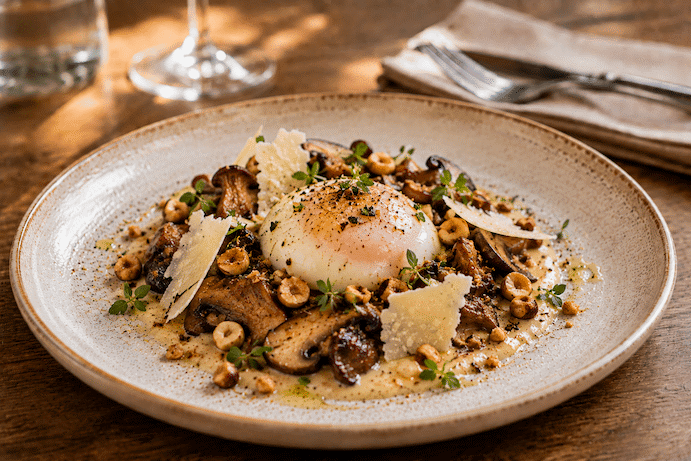 Œuf parfait au parmesan et champignons, dans une sauce forestière et pignon de pin